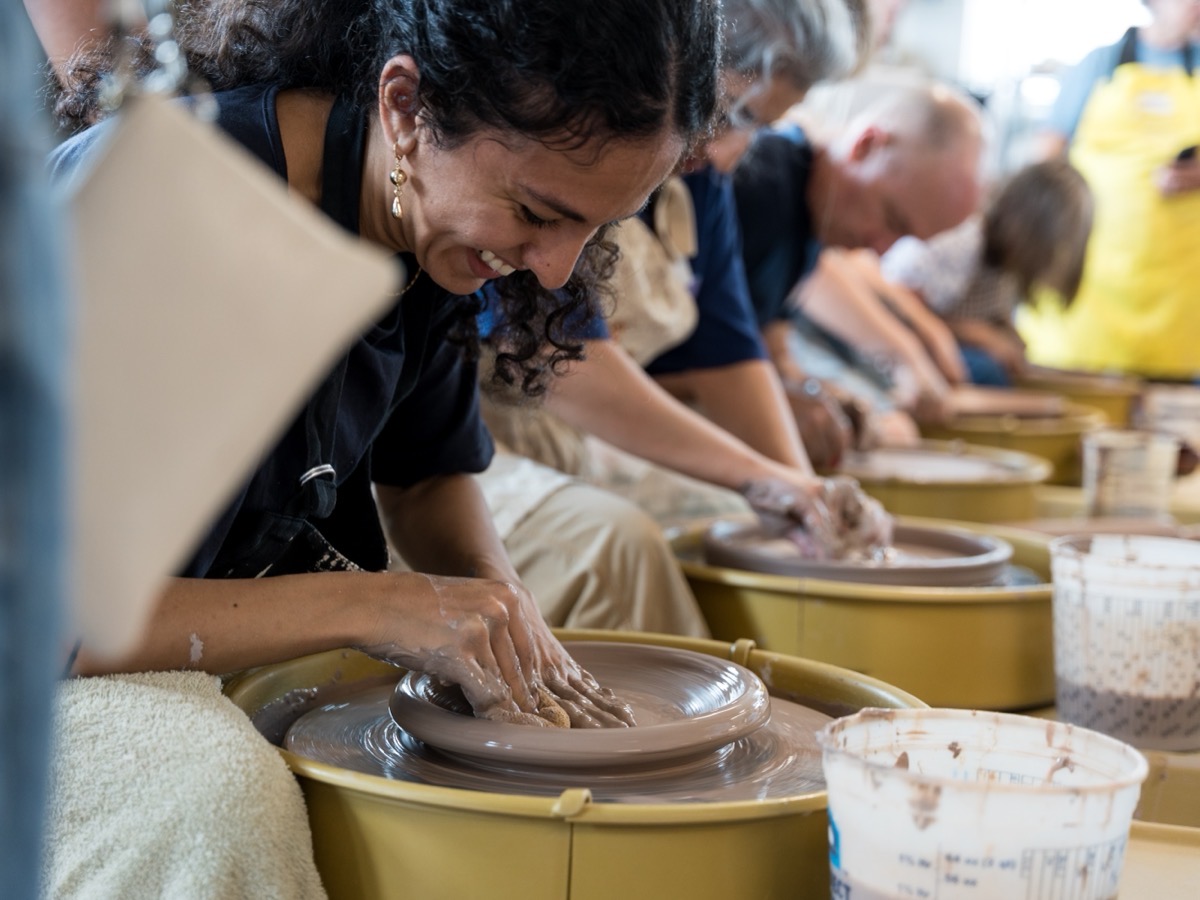 People shaping pottery at wheels during a Friendly City Clay workshop