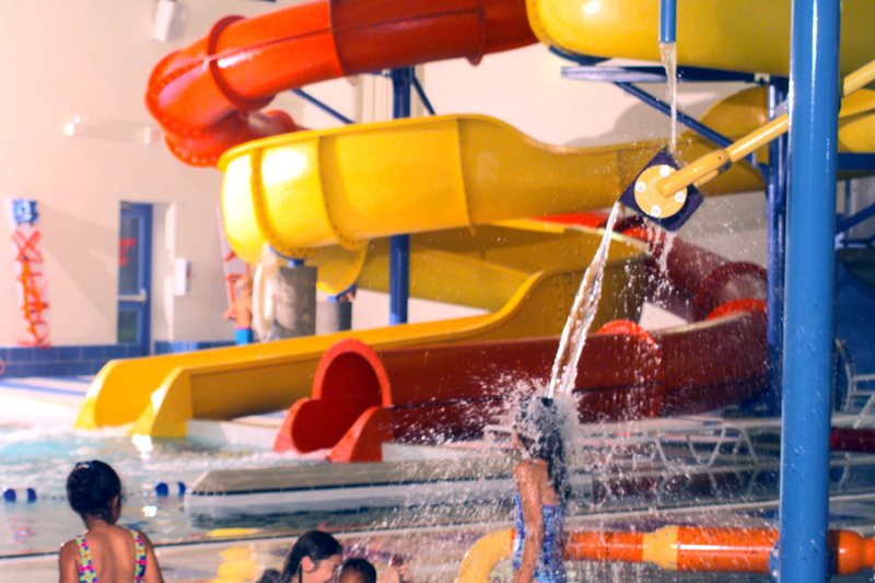Children playing in front of indoor water park slides (illustrative photo, not Massanutten)