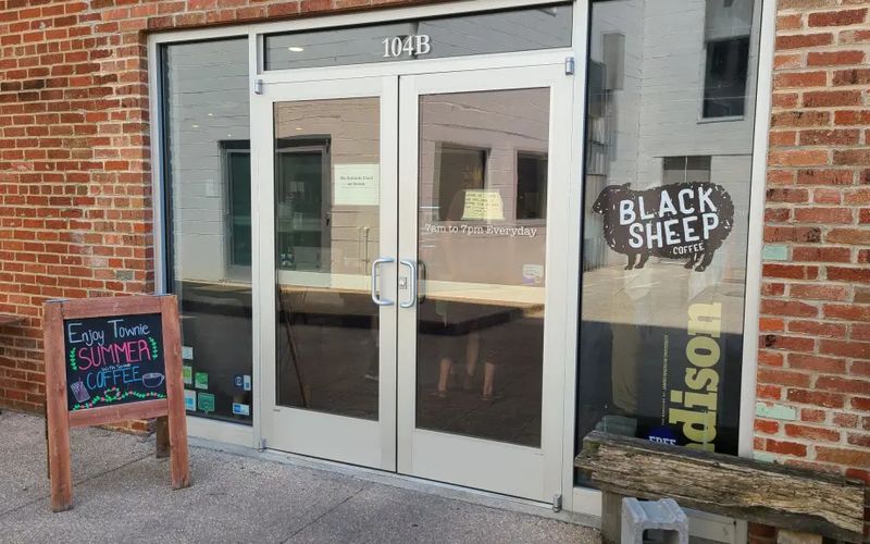 The glass storefront of Black Sheep Coffee in downtown Harrisonburg, with its black sheep logo in the window