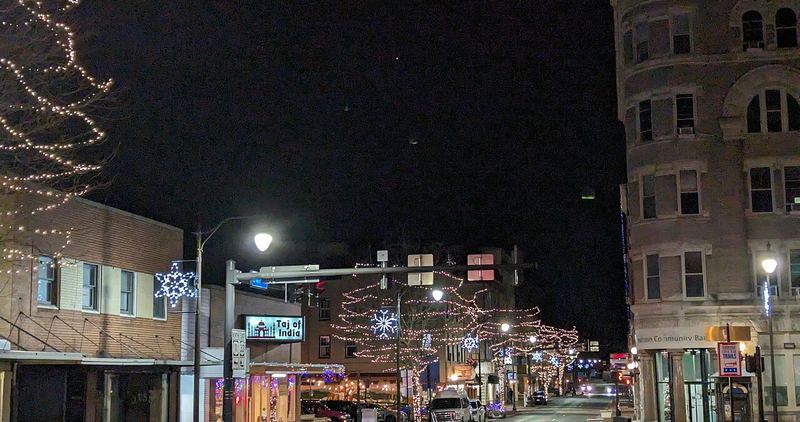 Downtown Harrisonburg glowing with holiday lights on a winter evening