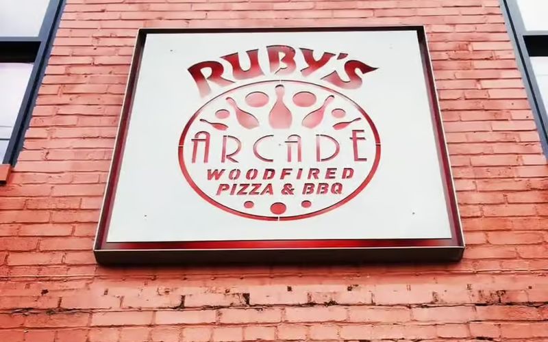 The Ruby's Arcade sign on a brick wall in downtown Harrisonburg: woodfired pizza and BBQ, duckpin bowling