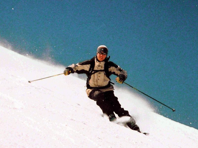 Skier carving a turn on a snowy slope